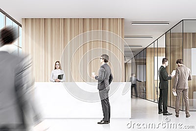Two men in suits are discussing work in a corner of an office hall. Stock Photo