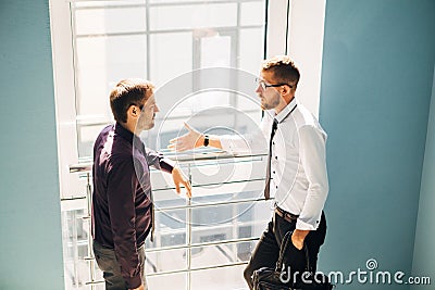 Two men talking in the lobby of the office Stock Photo