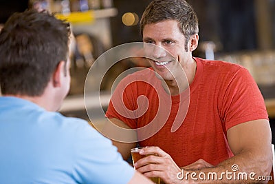 Two men talking over beer in a bar Stock Photo