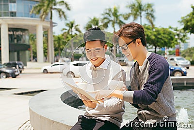 Two Men Using Tablet Computer Internet, Asian Friends Guys Sitting at Cafe Natural Light Stock Photo