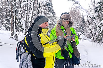 Two men in the winter forest launch a quadcopter Stock Photo