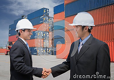 Two of Mid adult businessman shaking hands near cargo container Stock Photo