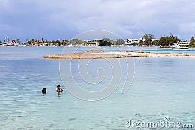 Two middle aged Micronesian women in closing enjoying swimming in rocky blue turquoise lagoon, Majuro city. Marshall islands. Editorial Stock Photo