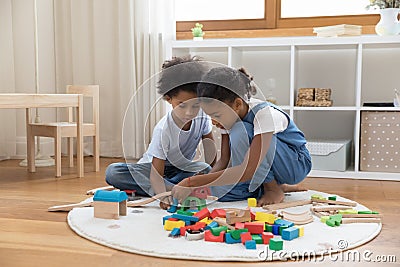 Two mixed race kids playing with heap of colorful toys Stock Photo