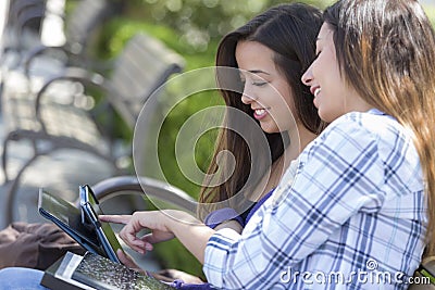 Two Mixed Race Students Using Touch Pad Computer Outside Stock Photo