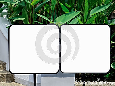 Two mockup of empty square standing sign on green leaves background. Stock Photo