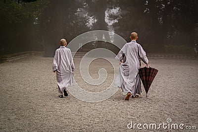 Two monks with umbrella at the morning prayer. Editorial Stock Photo