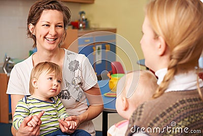 Two Mothers With Children Chatting At Playgroup Stock Photo