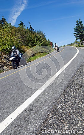 Two motorcyclists coming down a mountain road Stock Photo