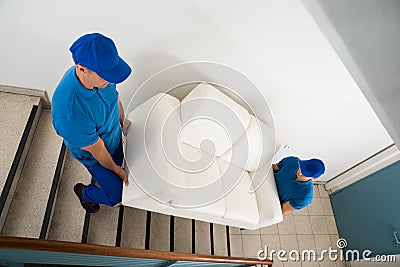 Two Movers Carrying Sofa On Staircase Stock Photo