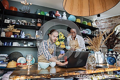 Two multicultural people working on laptop during inventory Stock Photo