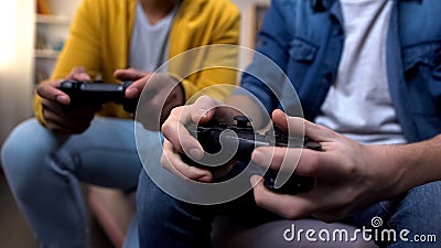 Two multiethnic teenage boys playing computer games at home, hands close-up Stock Photo