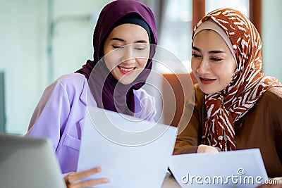 Two muslim women at home during lesson, studying near computer, online education. Culture, traditions, modern people. shopping Stock Photo