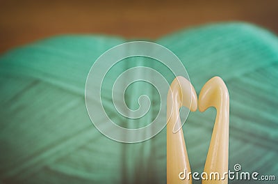 Two needles forming a heart in front of warm and cozy yarn ball of wool background. Stock Photo