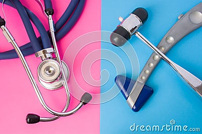 Two neurological rubber reflex hummers and medical stethoscope is in two colors background: blue and pink. Concept of neurological Stock Photo