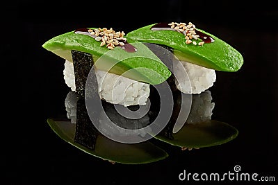 Two nigirizushi with avocado, unagi sauce and sesame Stock Photo