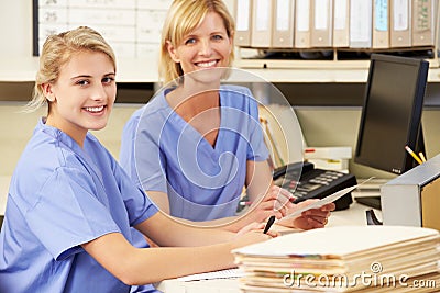 Two Nurses Working At Nurses Station Stock Photo