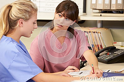 Two Nurses Working At Nurses Station Stock Photo