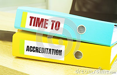 Two office folders with text TIME TO ACCREDITATION Stock Photo