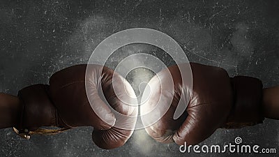 Two old brown boxing gloves hit together Stock Photo