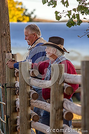 Two Old Cowboys Standing by Rail Fence Stock Photo