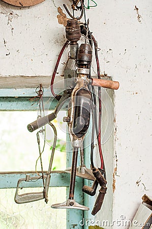 Two old hand drills hang on a garage wall Stock Photo
