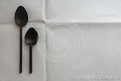 Two old iron spoons on white background with a copy space on the right Stock Photo