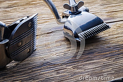 Two old manual haircut machine on old wooden scrached background. Stock Photo