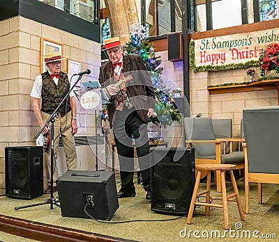 Two old men entertaining the crowd with the ukulele at the 2019 Christmas market in York, UK Editorial Stock Photo