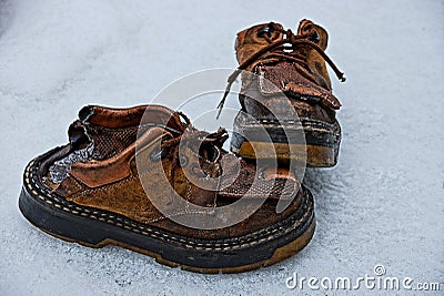 Two old ragged brown boots on the snow Stock Photo