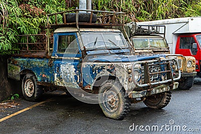 Two old rusty peeled paint farm trucks in an Asian village Editorial Stock Photo