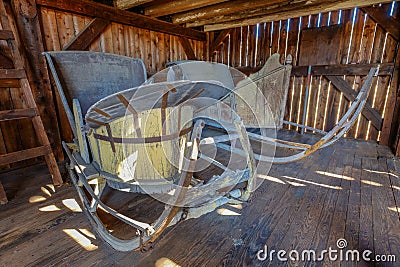 Two old wooden vintage sleighs or sleds in an old restored barn Stock Photo