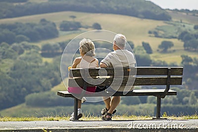 Two older people sitting on a bench Stock Photo