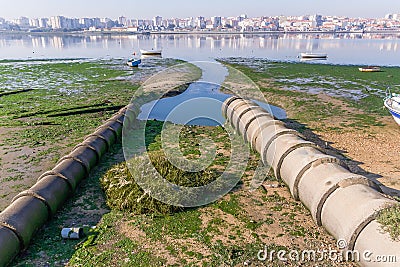 Two open air sewer pipes draining to the Seixal Bay Stock Photo