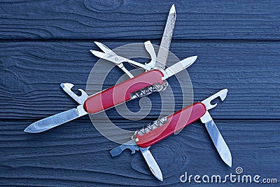 two open folding knives multitools with red handles with gray blades Stock Photo