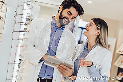 Two ophthalmologists using digital tablet in an optical store Stock Photo