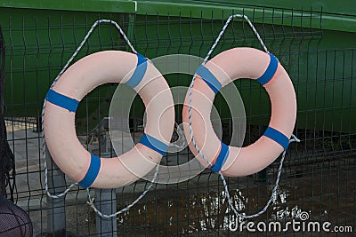 Two orange lifebuoys on hanging on a wooden wall of a boat station photo Stock Photo