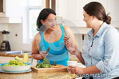 Two Overweight Women On Diet Preparing Vegetables in Kitchen Stock Photo