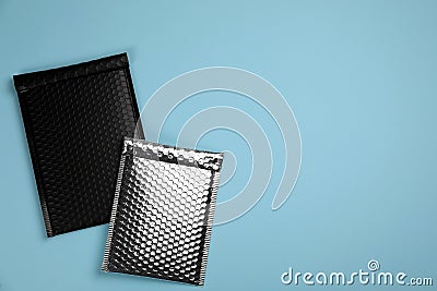 Two padded envelopes with bubble wrap on turquoise background, flat lay. Space for text Stock Photo