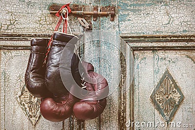 Two pair of vintage boxing gloves hanging on a weathered ancient Stock Photo