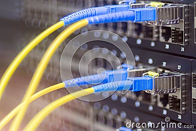 Two pairs of fiber optic patch cords are connected to a manageable Internet switch. Server hardware datacenter. The concept of Stock Photo
