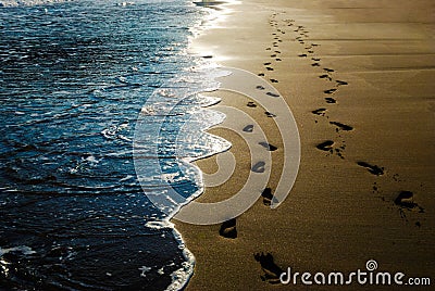 Two pairs of footprints in the sand on the beach Stock Photo