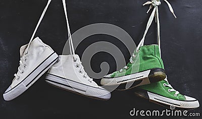 Two pairs of used textile shoes hang Stock Photo