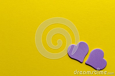 Two paper purple hearts on yellow background Stock Photo