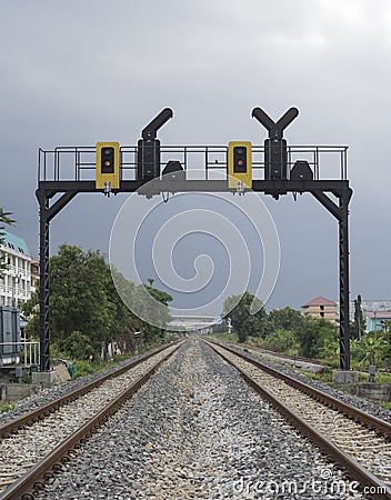 Two parallel railway pass in a city with a railway traffic light Stock Photo
