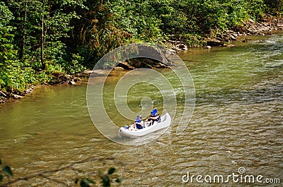 Two people drifting boat swift mountain river Stock Photo