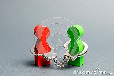 Two people are handcuffed to each other. Unclosed obligations between two persons, financial or moral debt. Contract, duty Stock Photo
