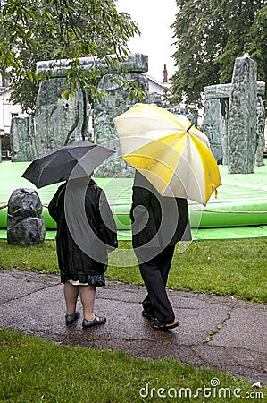 Two people look at the inflatable Stonehenge Editorial Stock Photo