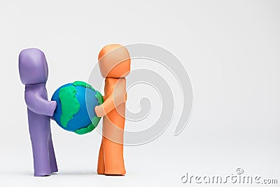 Two people made from plasticine of different colors holding a model of planet earth Stock Photo