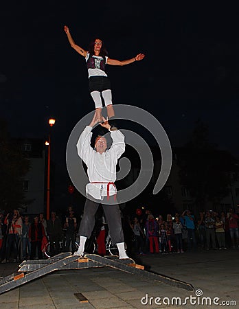 Two performance artists balance on top of a bridge Editorial Stock Photo